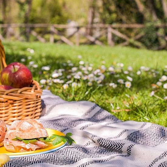 a picnic basket laying on a towel on the ground