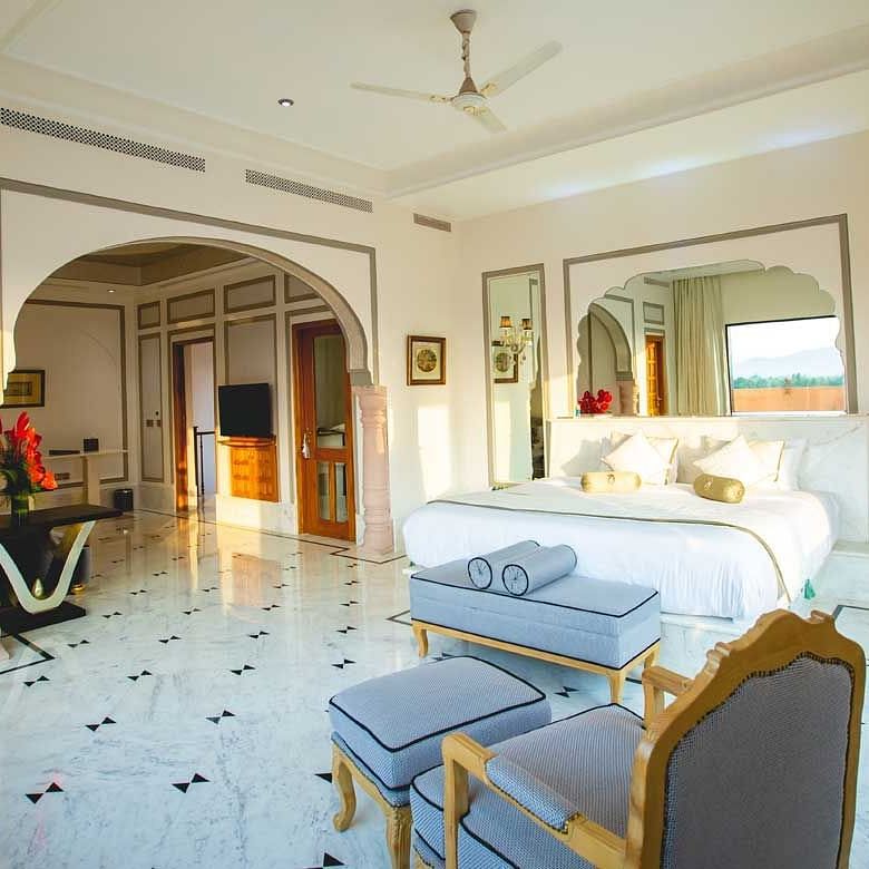 the king size bed along with a sofa set by it facing the window - Buena Vista Luxury Garden Spa Resort 1
