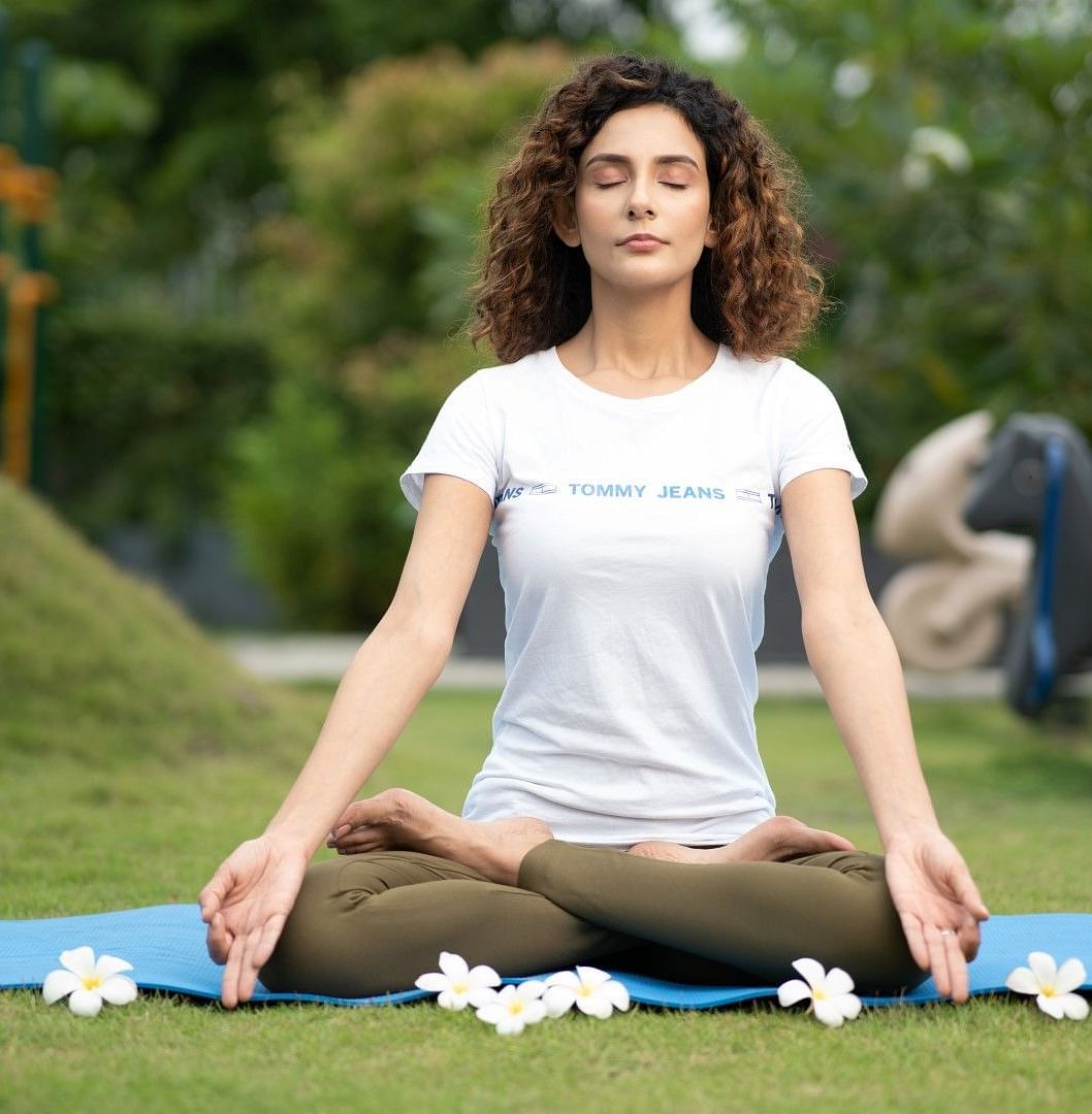 A  lady meditating in a park
