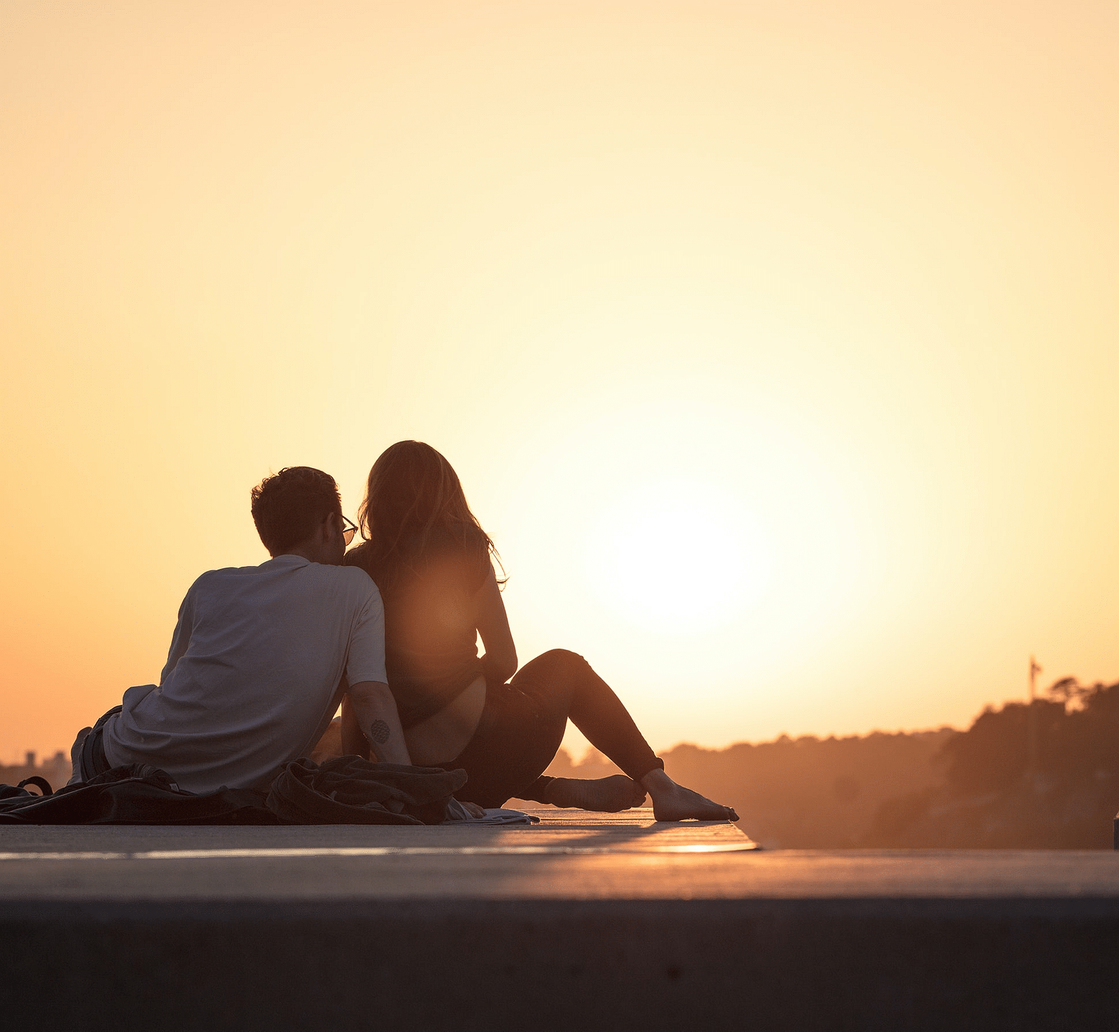 image of a couple sitting together watching the beautiful sunset