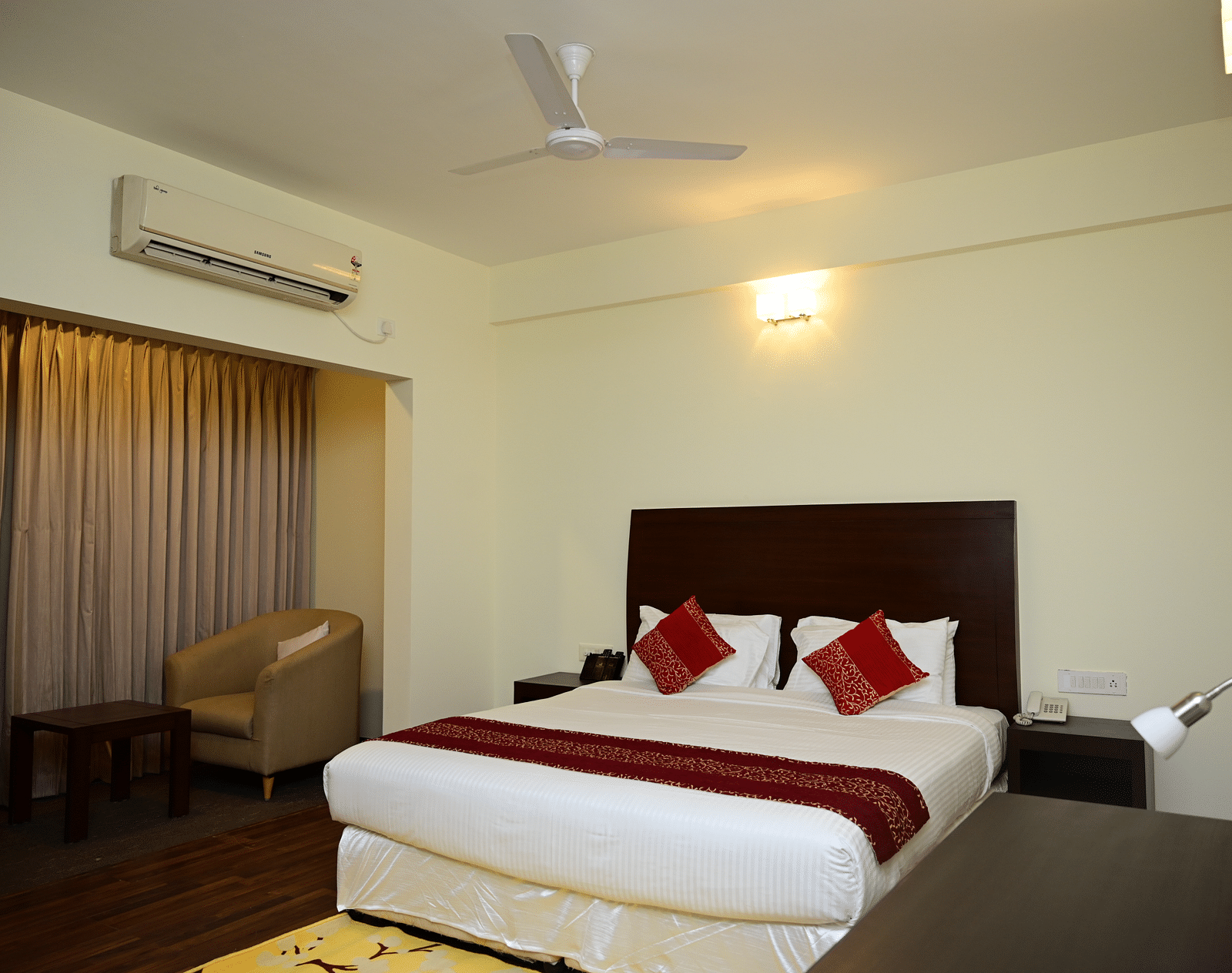 A double bed with red blanket and red pillow covers in the Executive Suite at Sterling Keys by TGI 4