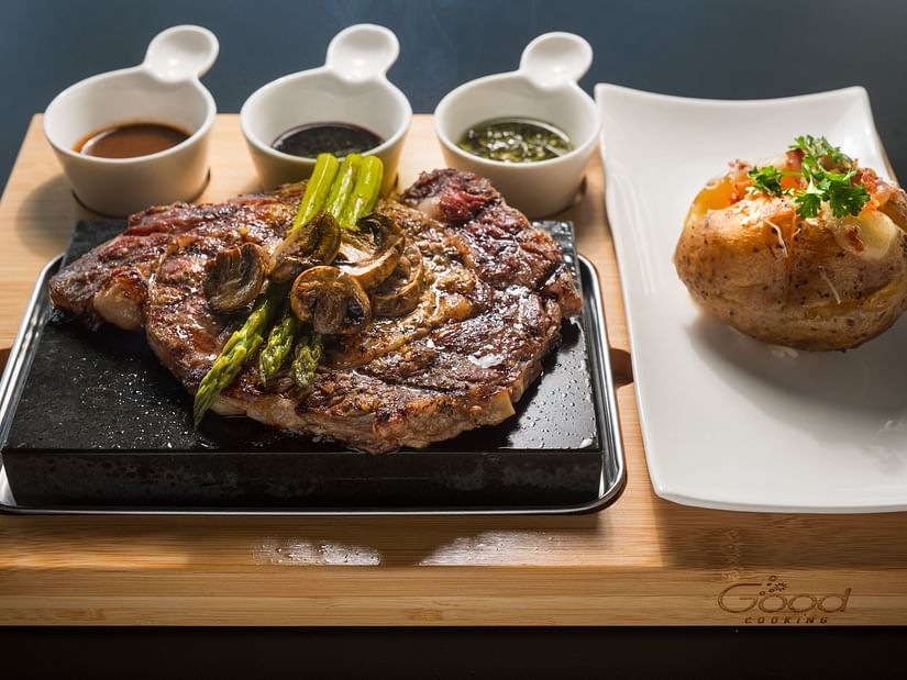 An image of a steak with sauces and a dish made of bread presented in an elegant manner - S Hotel Kingston, Jamaica