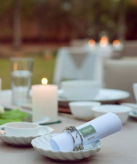A table set with candles and small bowls, outdoor setting - Shreyas Retreat