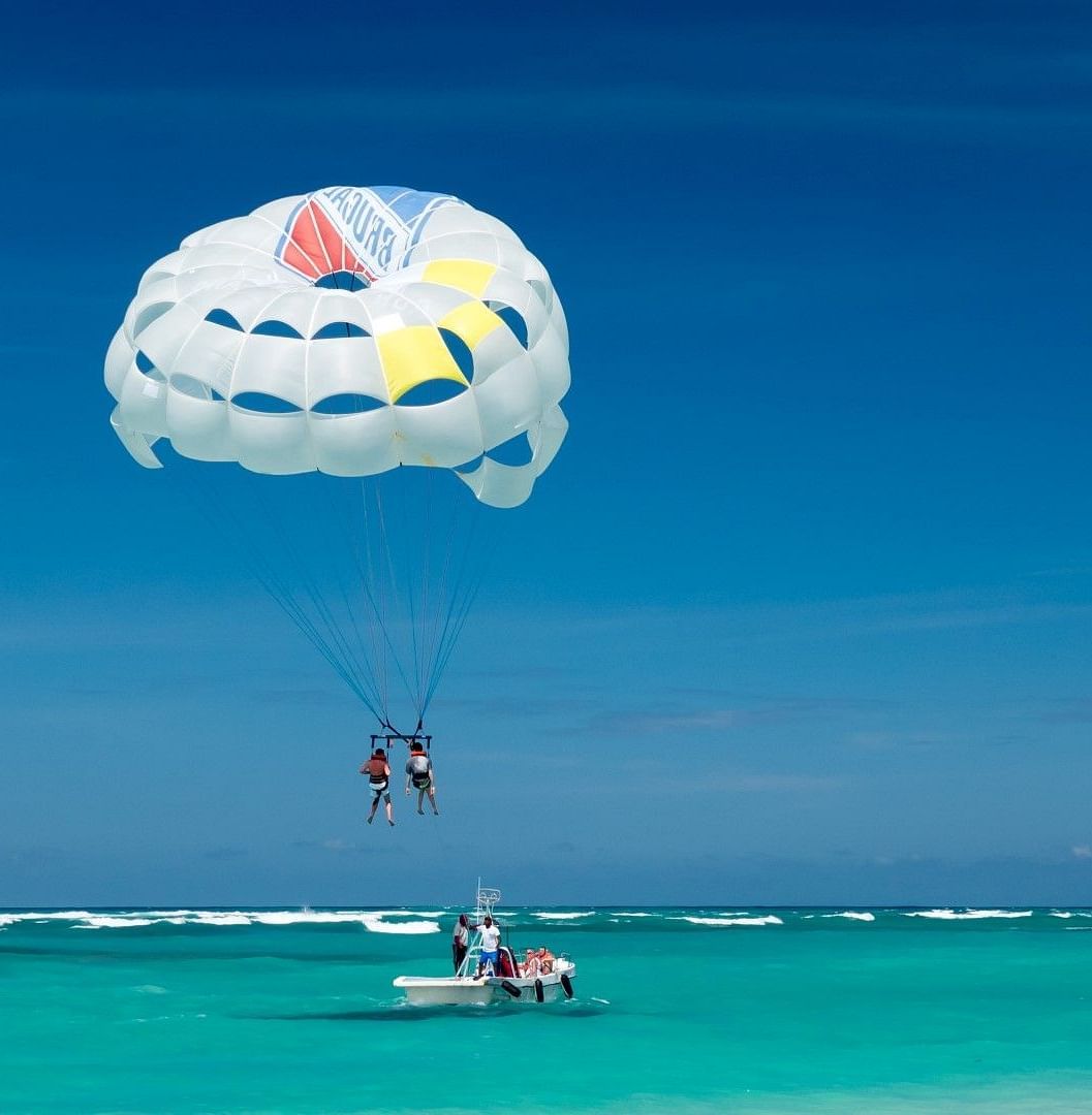 two people parasailing at a beach in goa