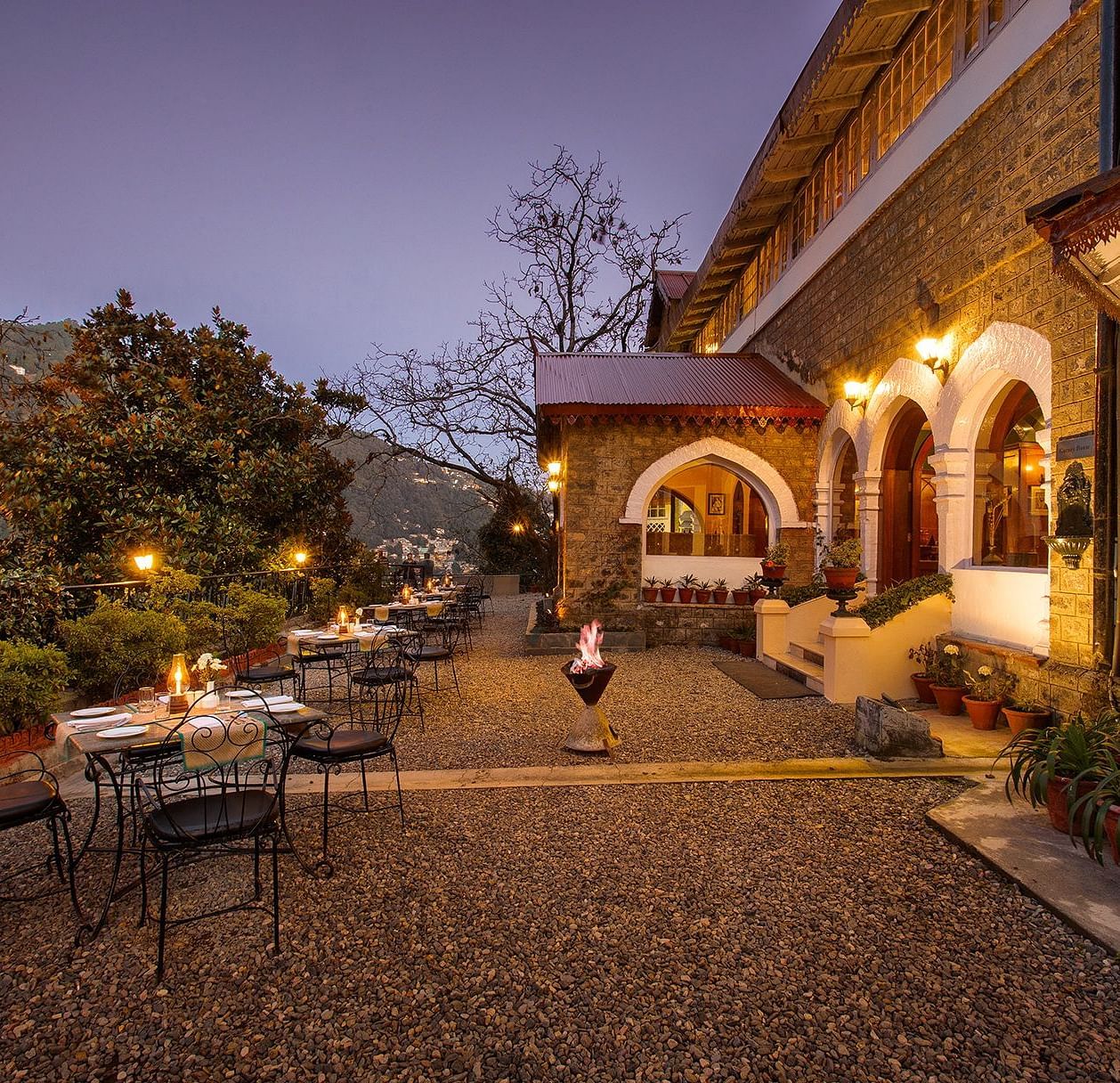 Hotel exterior with a garden and lighting.