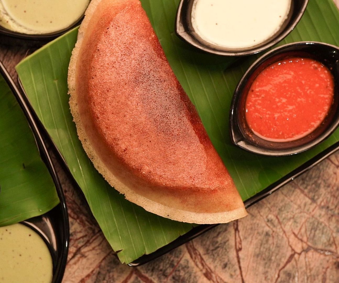 A Dosa and bowls of chutney from Mulbagal Dosa Corner at Hotel Pai Viceroy Jayanagar