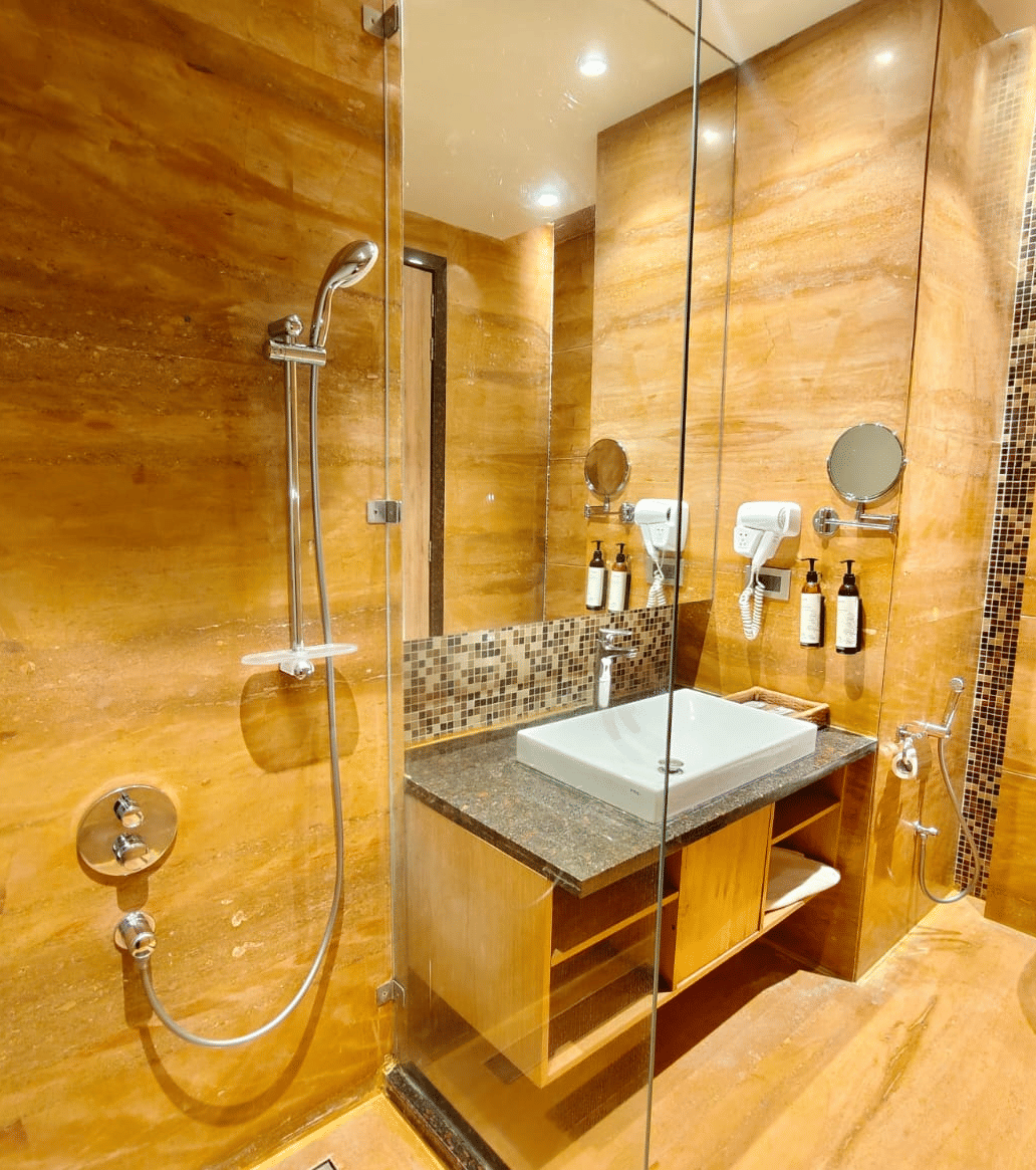 A contemporary bathroom featuring walls with a distinct horizontal wooden or stone grain, a glass-enclosed shower area, a square vessel sink on a vanity, and a wall-mounted toilet.