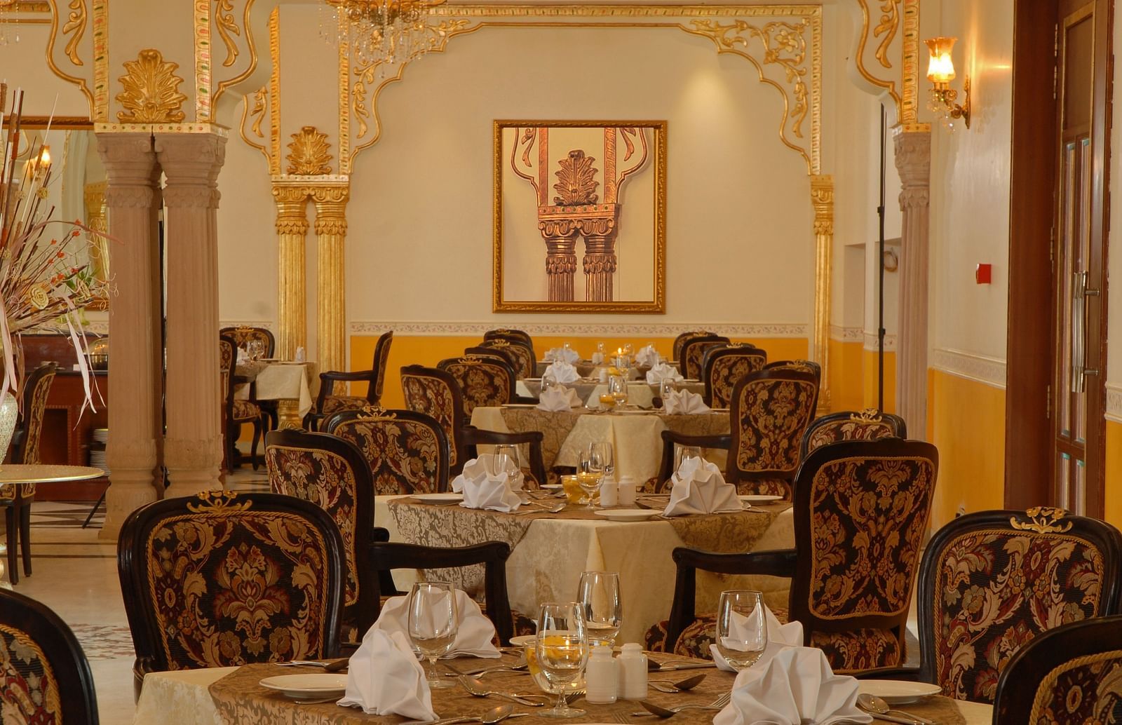 Image of a dining space with seating area a photo frame on the wall at Rajasthali Resort & Spa Jaipur.