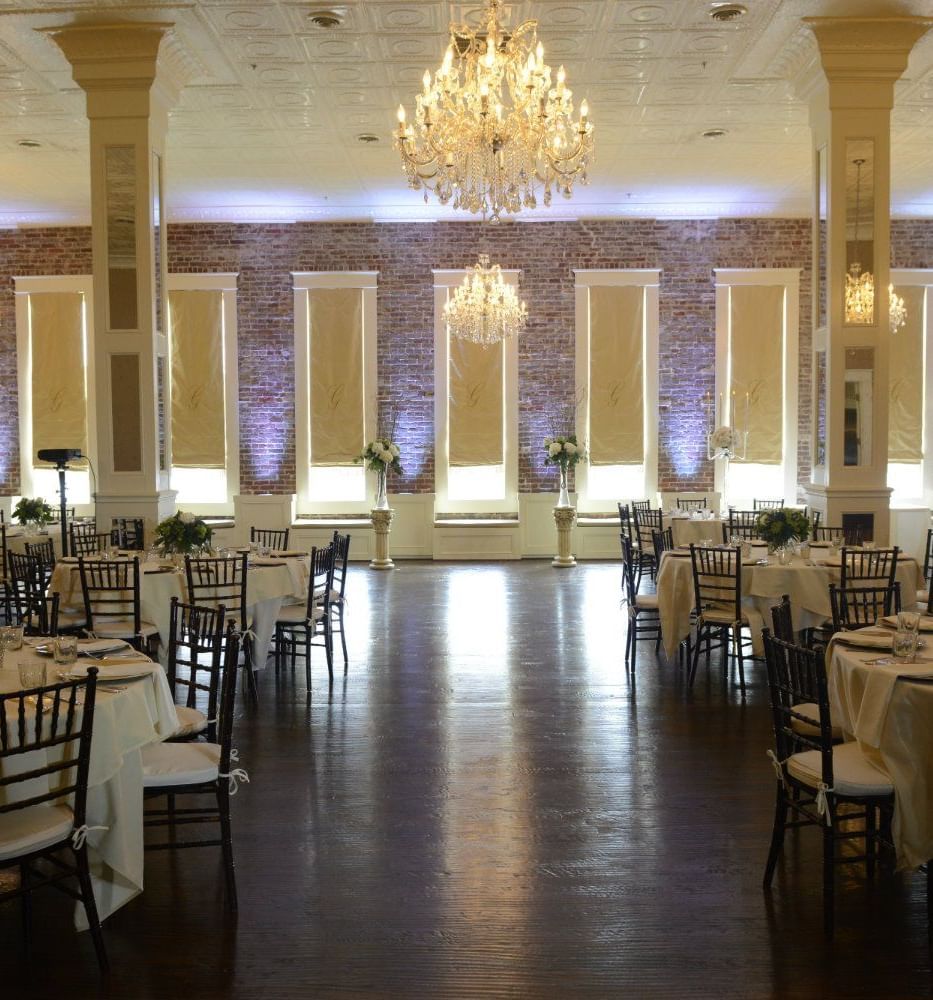 Grand banquet hall with crystal chandeliers and white linens perfect for events and celebrations
