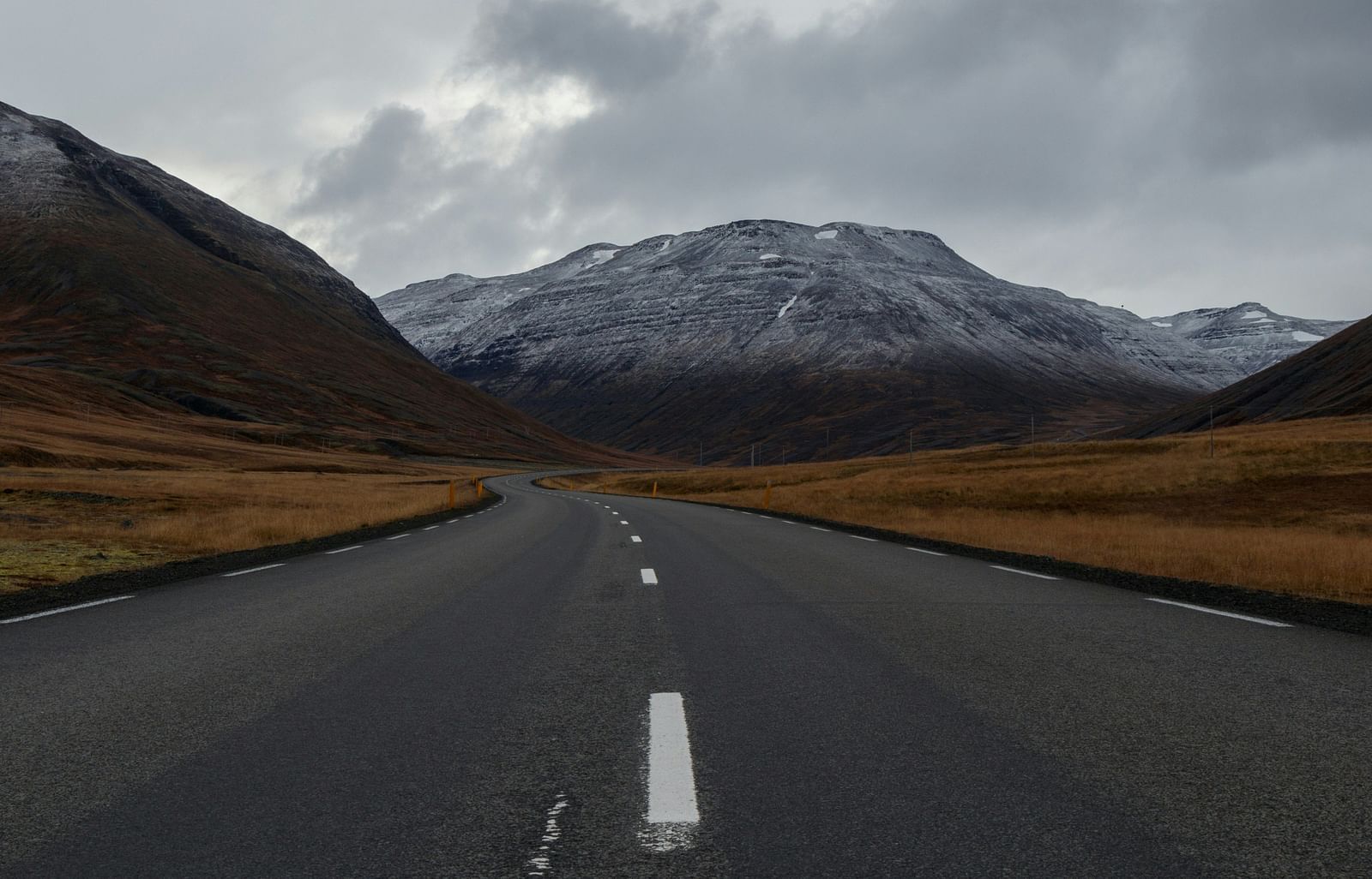 An overview of a highway with single lanes on either side and a mountain in the background.