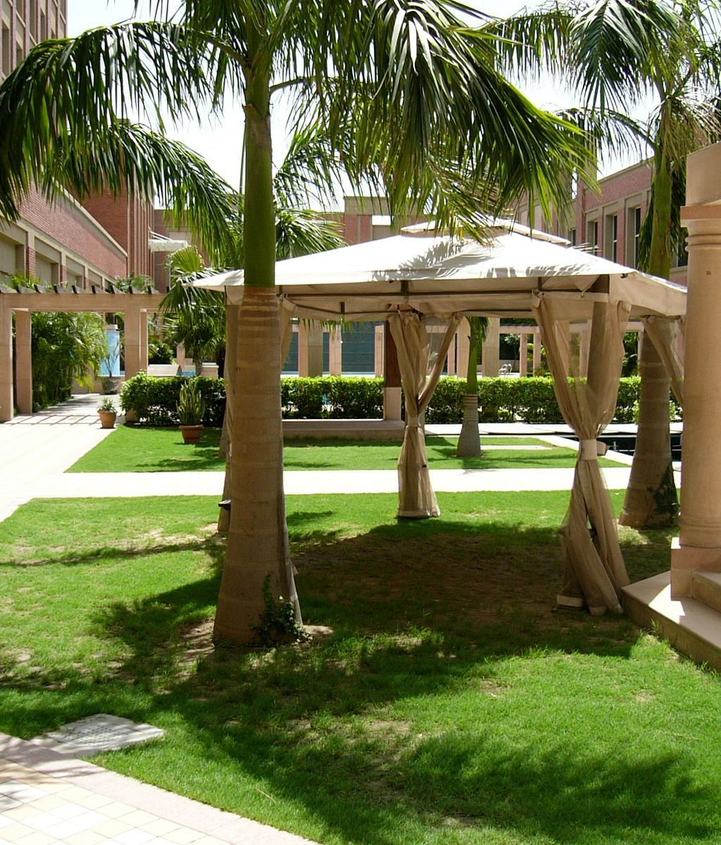 A sunshade surrounded by greenery at Nirvana Luxury Hotel, Ludhiana.