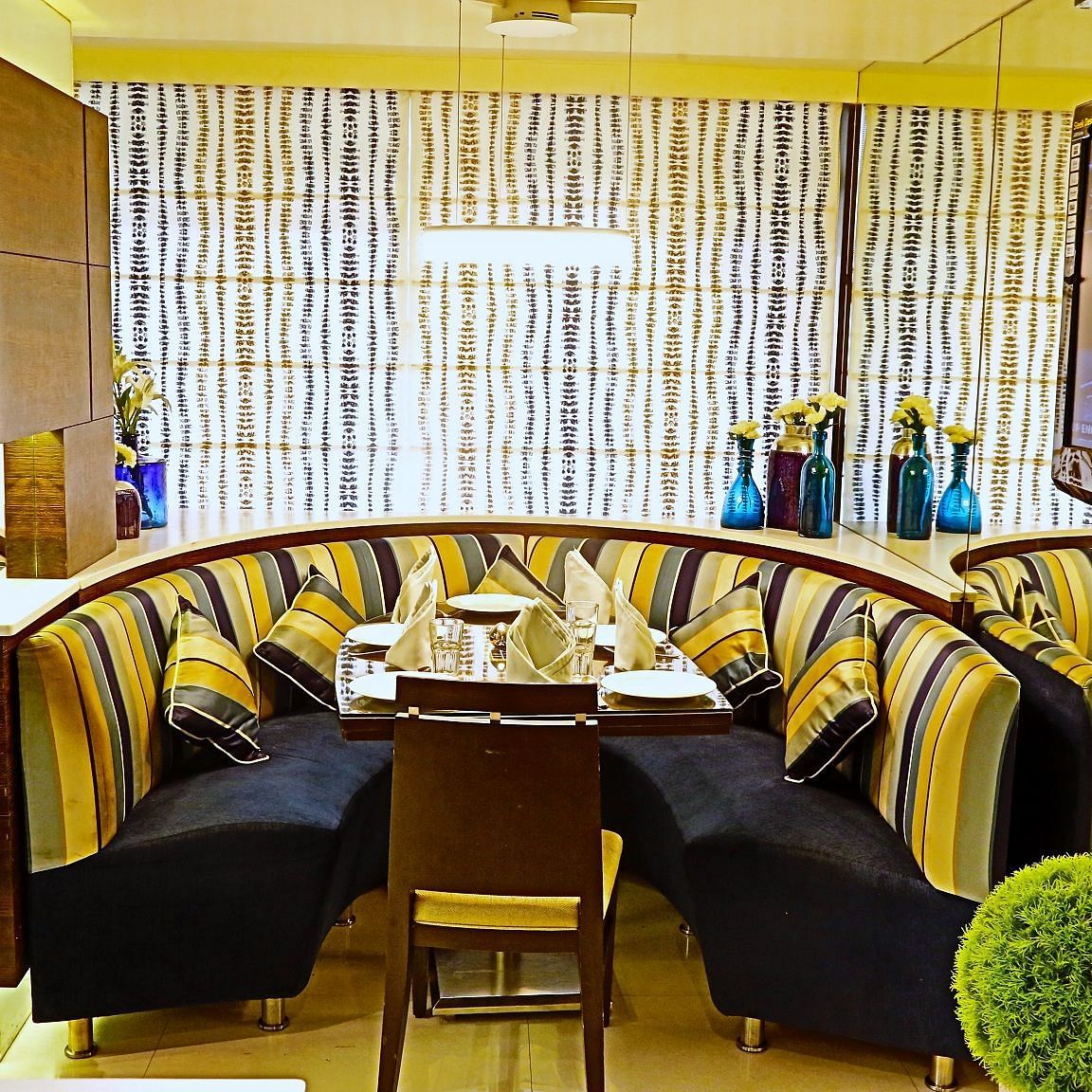 Image of a dining corner with sofas and plants on the side  at The Oriental Residency