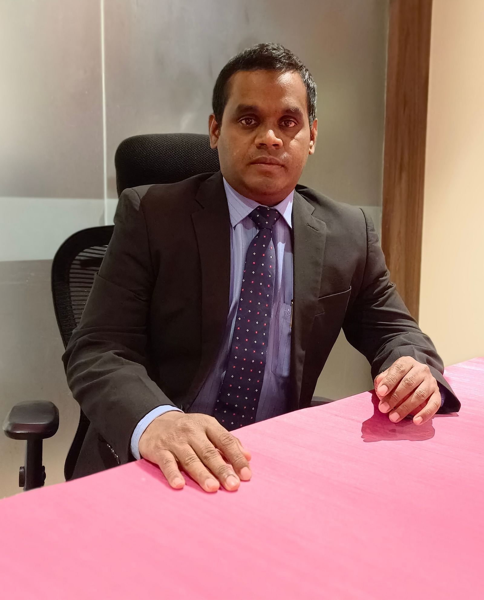  Mr Amin sits at his desk, focused and composed