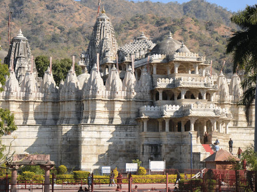A far away view of a white temple with a hill in the background