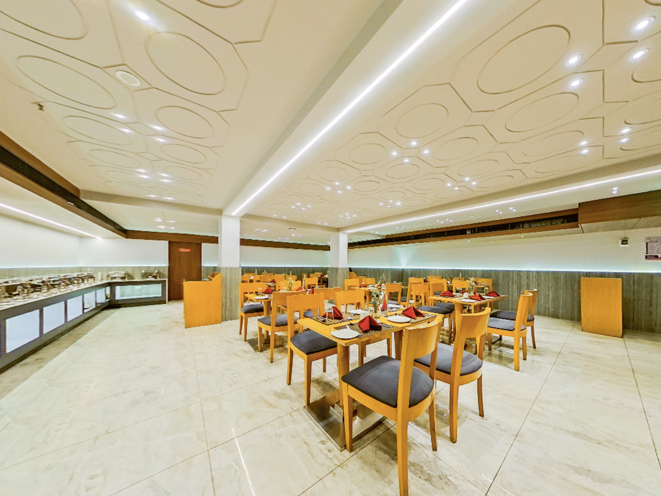 Spacious dining hall featuring buffet counter and multiple seating areas at Lords Eco Inn Dahej, with elegant marble columns and decor