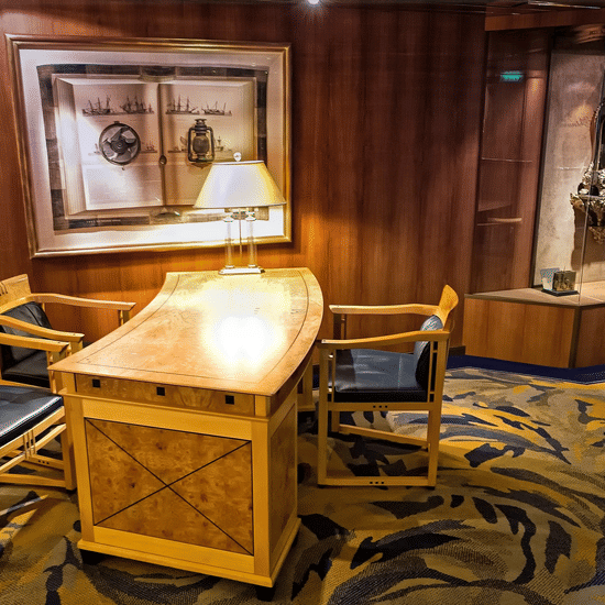 A antique front desk with a table lamp, chair. 