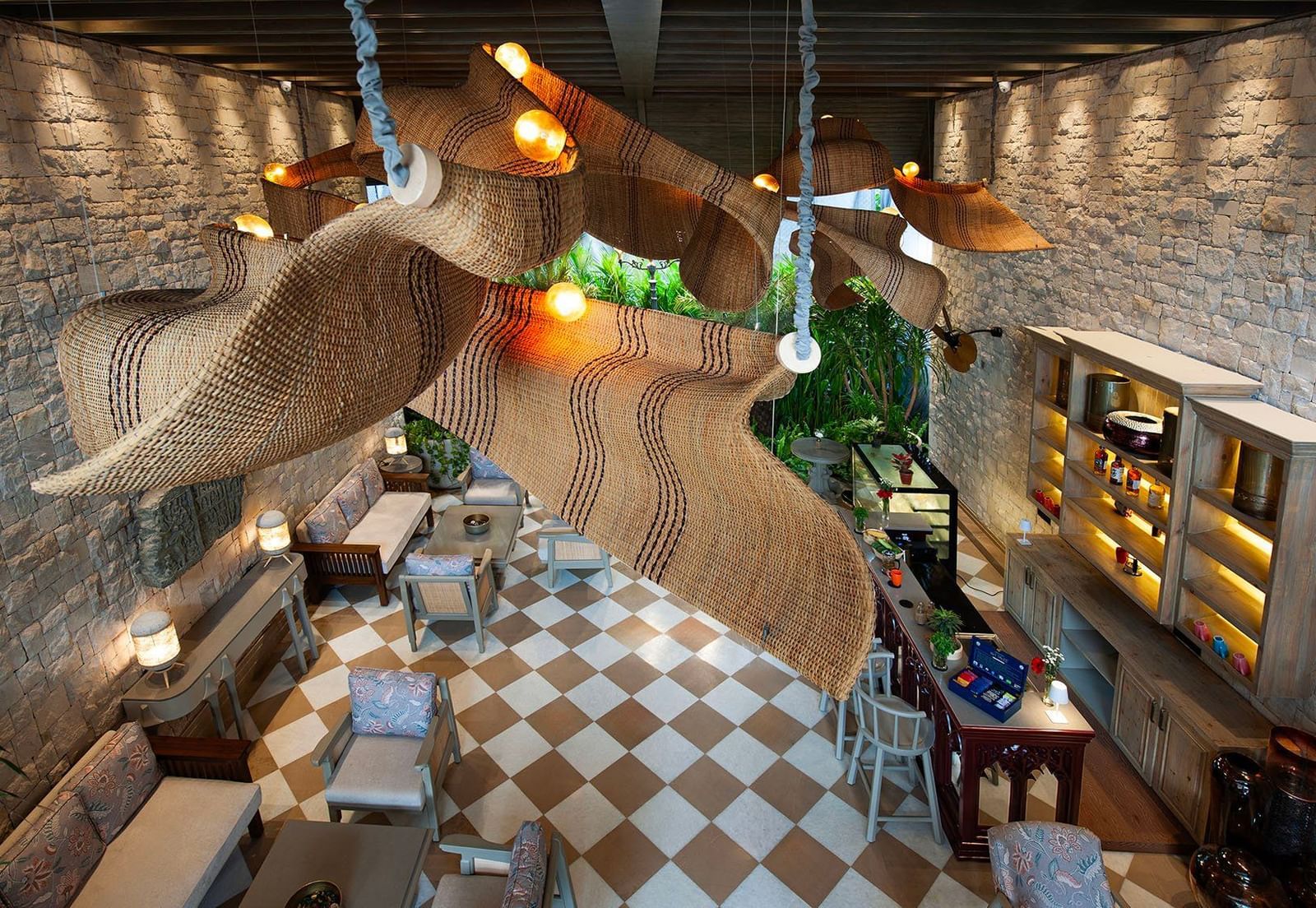 A top-angle shot featuring the unique chandelier hanging from the ceiling above the Suenos de Cafe at The Evren, Vagator.