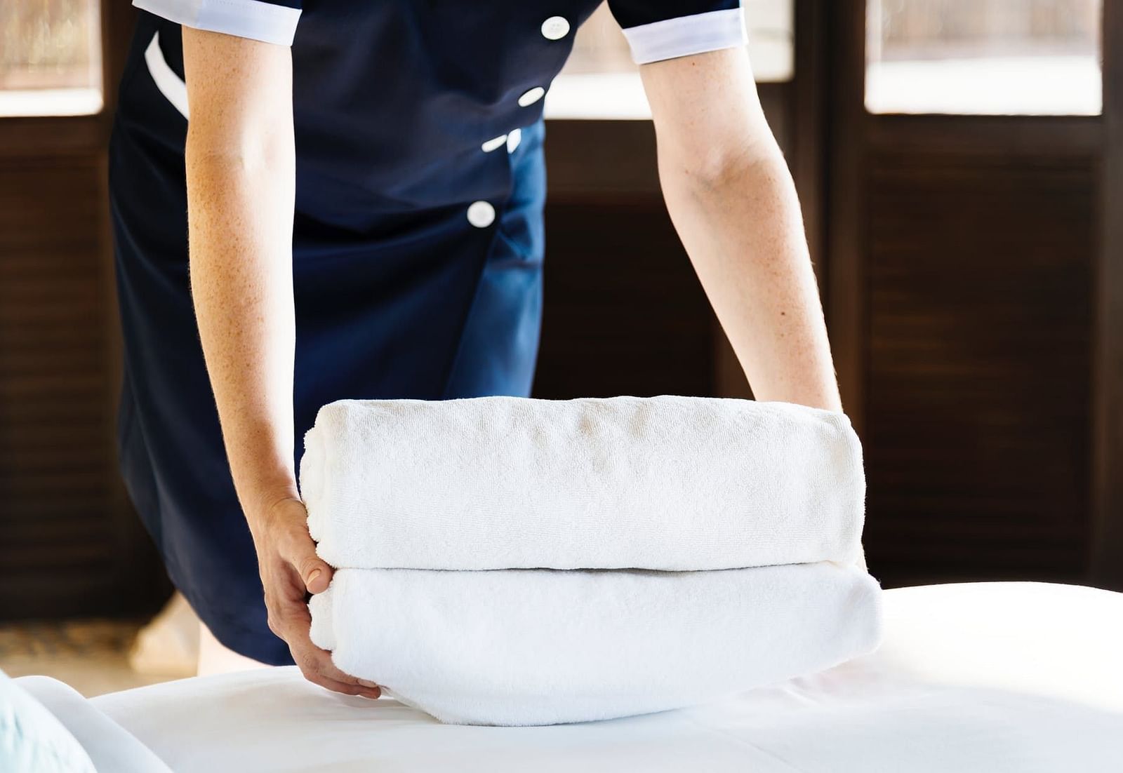 Image of two hands holding two folded towels.