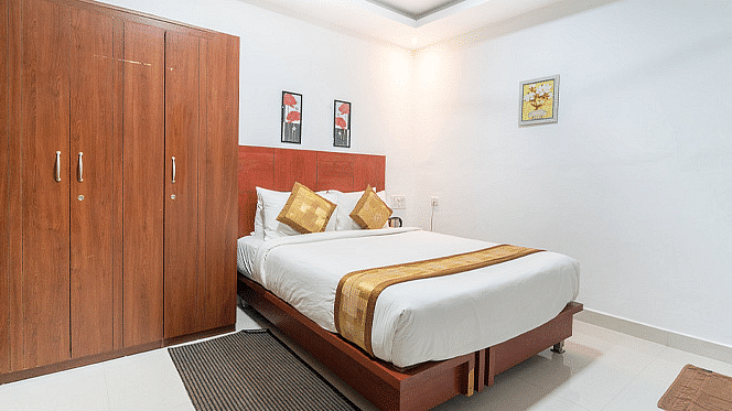 A room with a bed and a wooden wardrobe beside it at Coorg Jungle Camp Backwater Resort, Kushalnagar.