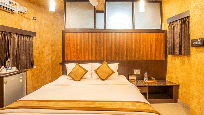 A room with a bed and wooden bedside table at Coorg Jungle Camp Backwater Resort, Kushalnagar.