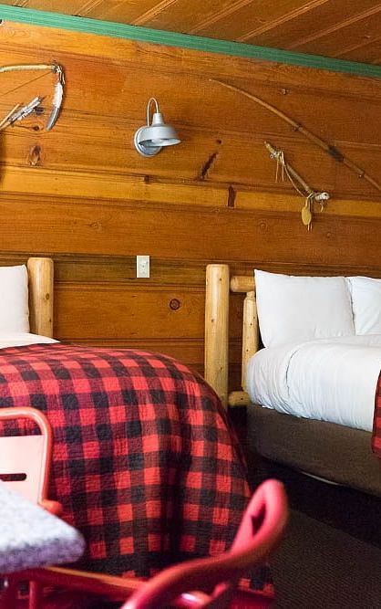 A wooden cabin with twin beds at Shaver Lake Village Hotel.