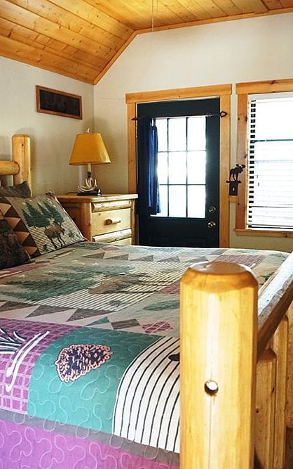 A room with a double bed and wooden panelling on the ceiling at Shaver Lake Village Hotel.