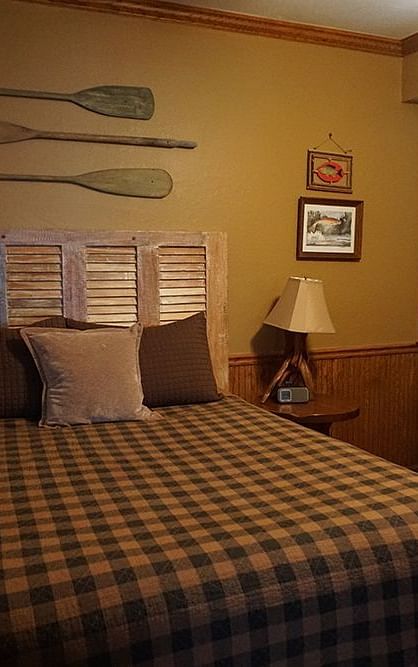 A room at Shaver Lake Village Hotel with a double bed and wooden oars hung on the wall behind it.