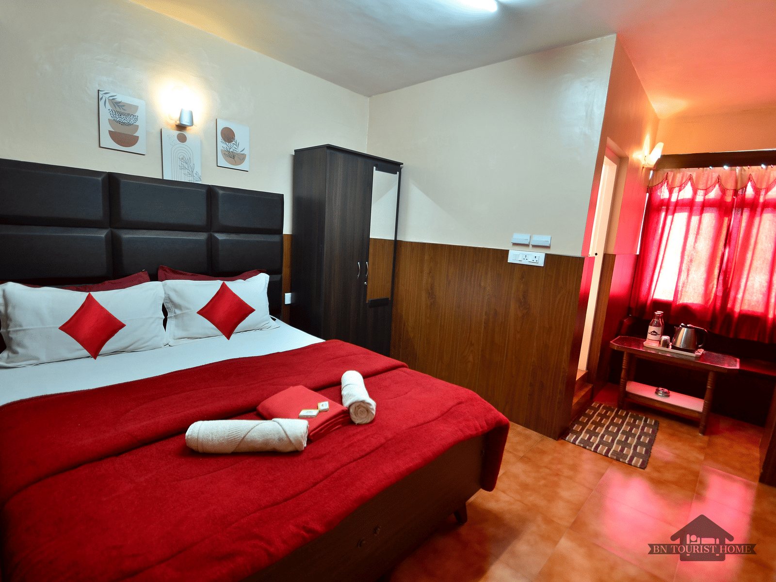 Image of a room with a double bed and a wardrobe on the side at BN Tourist Home, Ooty