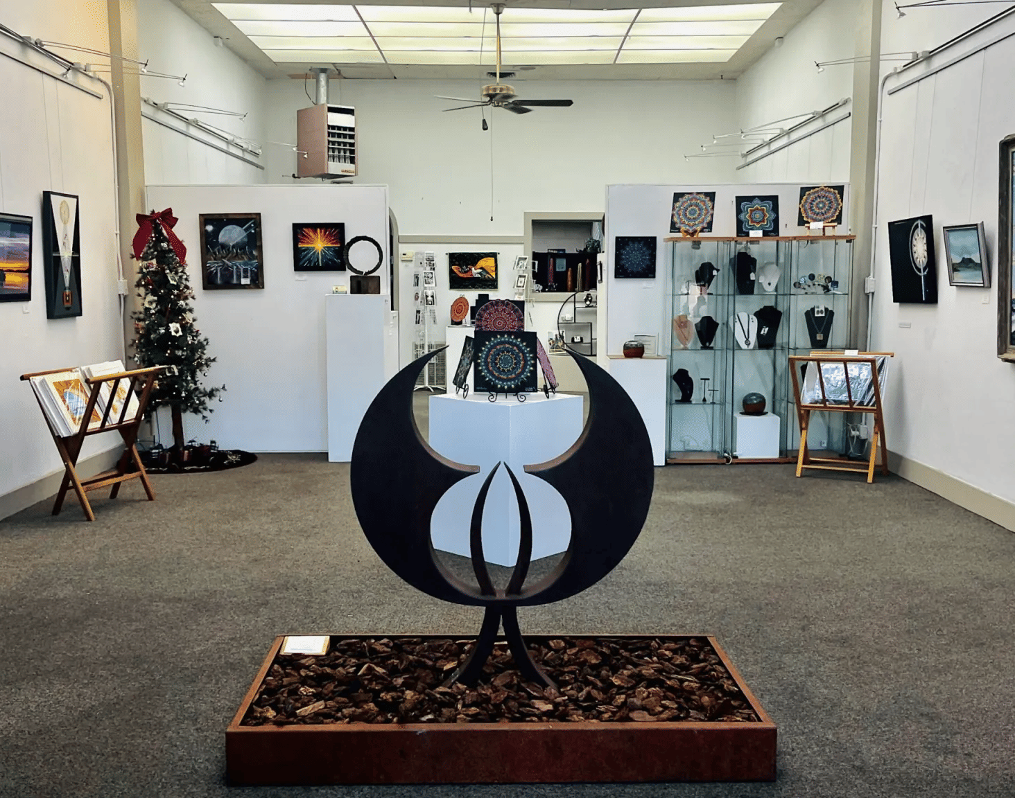 An art gallery at the Tallman Hotel features a unique black and white sculpture surrounded by various artworks.