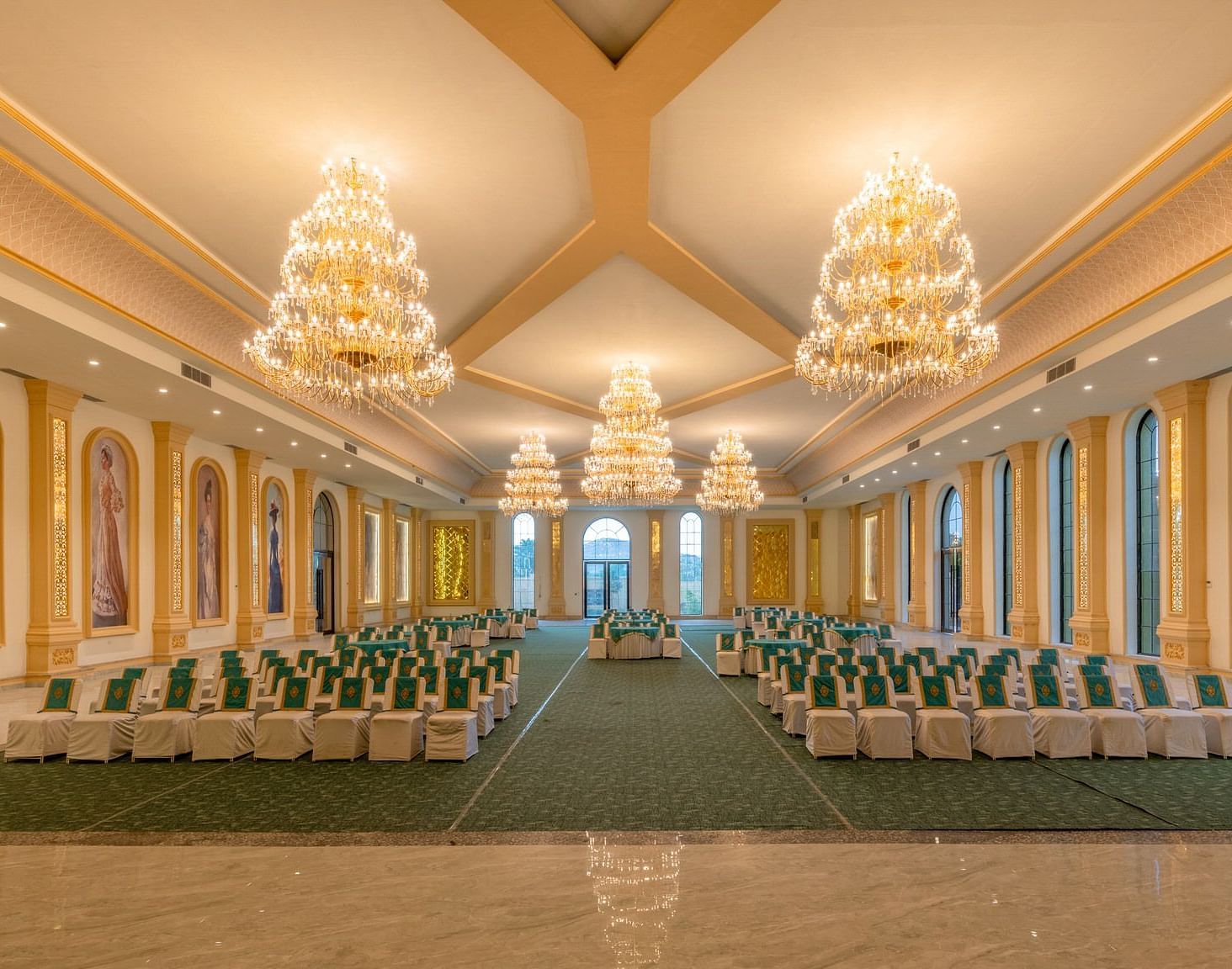 Front view of a banquet hall with neatly arranged chairs and chandeliers adorning the ceiling at Valley by Grassfield.