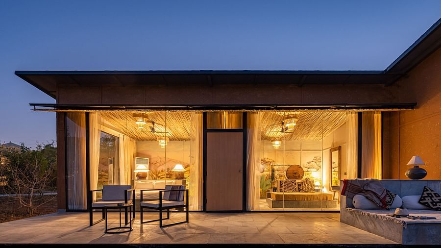 A facade image of a room with bright lighting and greenery around - Utsav Camp Sariska