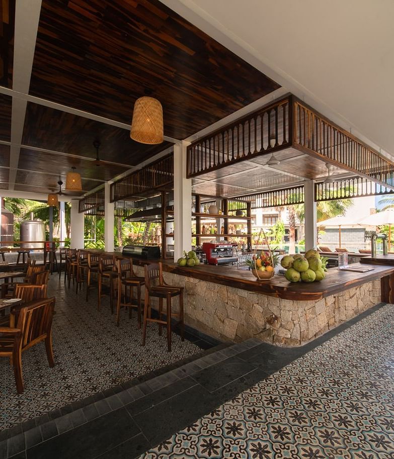 A well maintained restaurant at our hotel with flower printed tiles, comfortable wooden furniture and lamps hanging from the ceiling - Alibu Resort Nha Trang