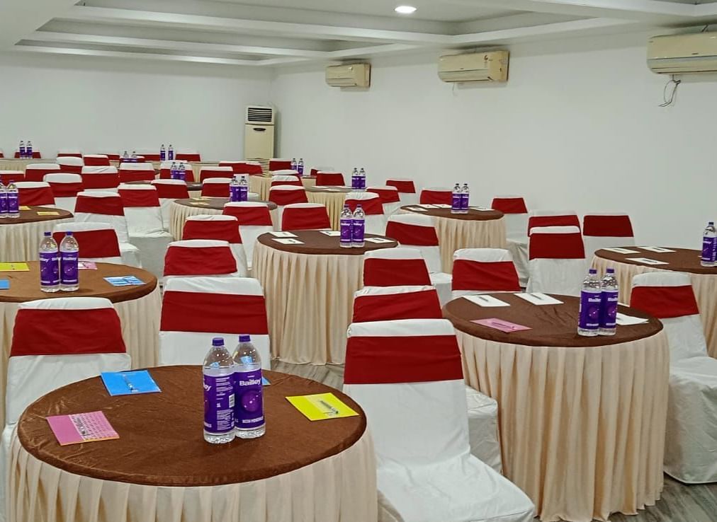 Round tables and chairs covered with cloth, and warm overhead lighting enhance and reside in the Emerald banquet hall of Mountview Resort.