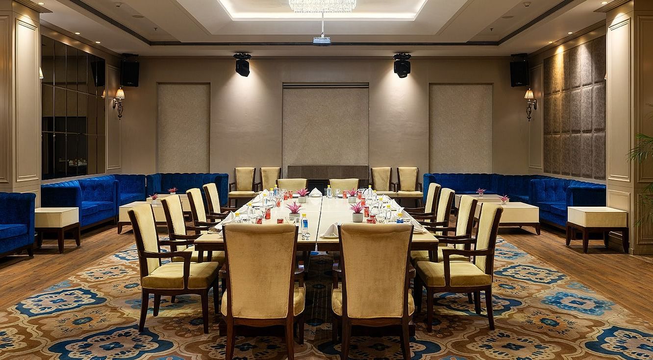 A meeting hall with chairs placed facing a huge table at Nirvana Luxury Hotel, Ludhiana.