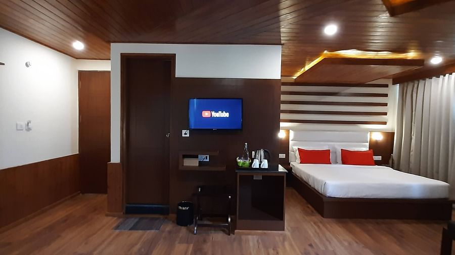 Front-view of family suite at Mastiff Xanadu in Manali with a bed, TV and a work desk