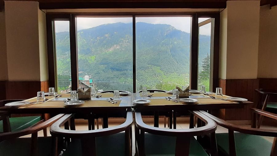 Restaurant seating area along with scenic view from the window - Mastiff Xaandu, Manali