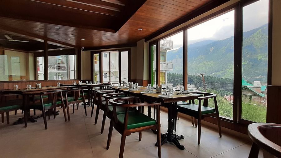 Wide shot of restuarant in Manali at Mastiff Xanadu Hotel along with valley-view windows