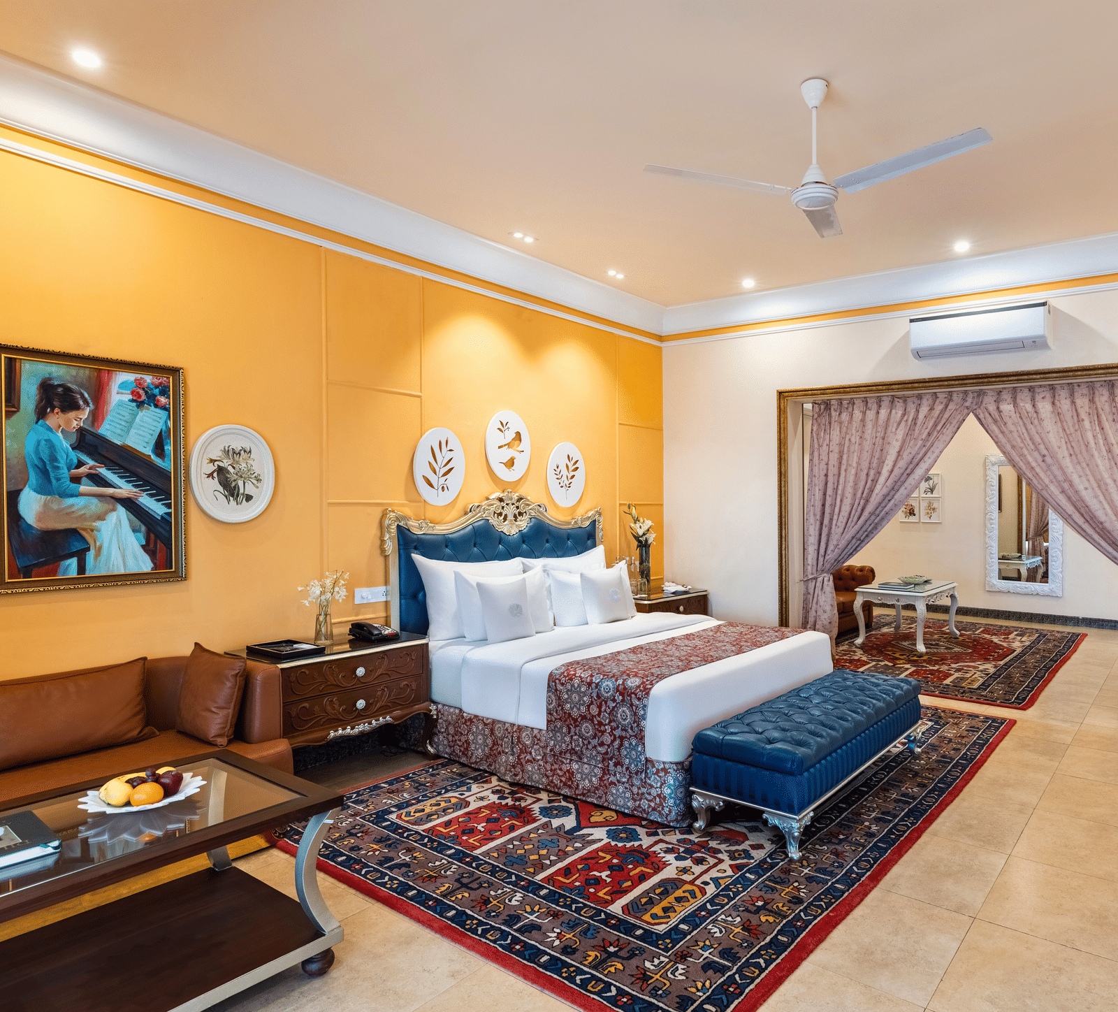 Family suite with a king bed, a seating area, a sofa, a coffee table and an adjoining room through an archway at MAYFAIR Palm Beach Resort, Gopalpur-on-Sea.