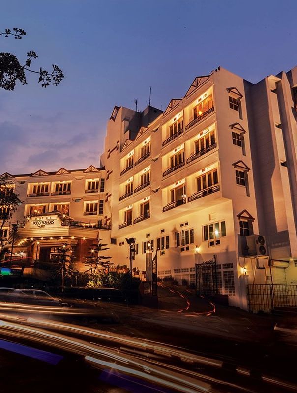 A hotel building lit up in the evening with car trails in front - Polo Hotel Shillong