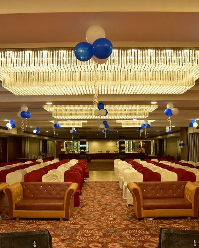 A decorated banquet hall at Rang Lords Inn, with arranged seating and festive balloons, prepared for a celebration or event