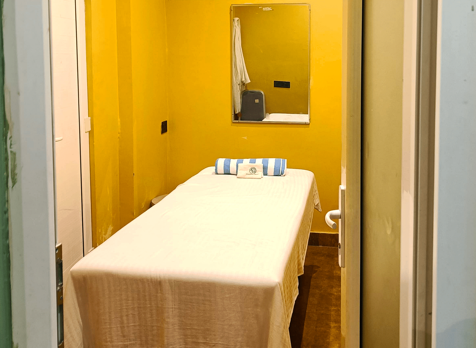 Spa room at DLS Forest Vines Resort as seen from the entrance, with a neatly made massage bed.