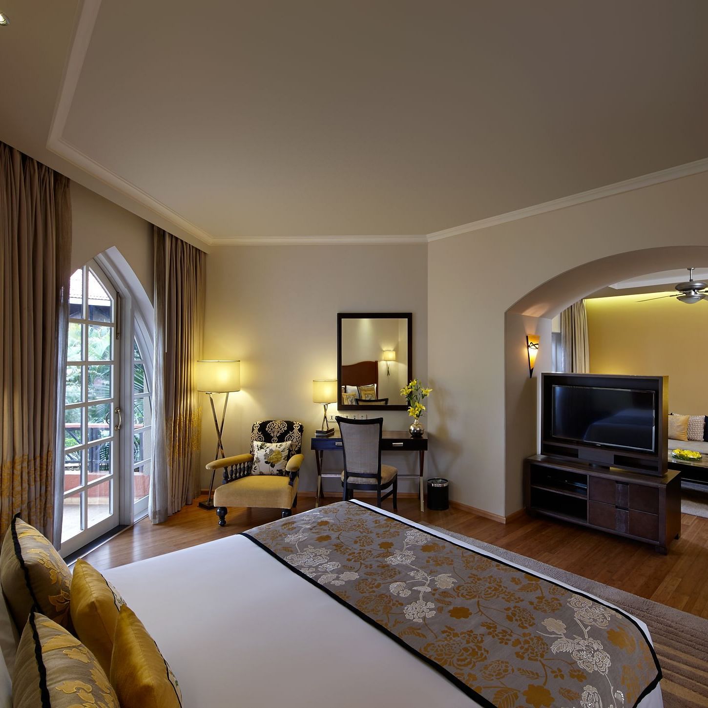 a double bed with a tv and living room opposite it inside Suite - Caravela Beach Resort Goa