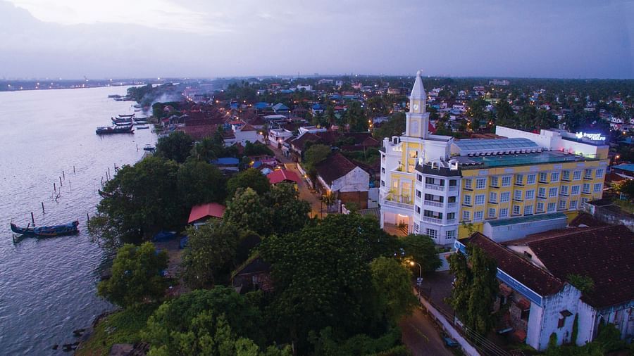 Aerial view of the hotel with the sky and beach in the background, surrounded by trees
