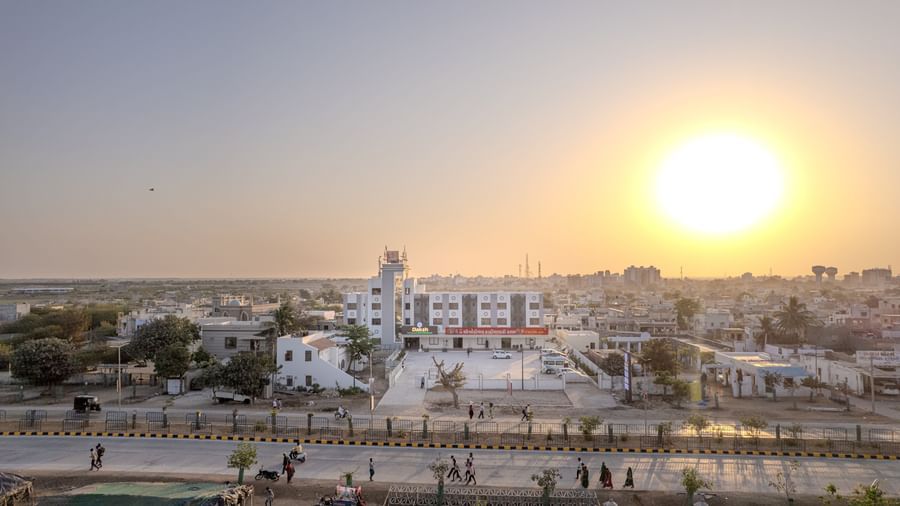 Aerial view of Daksh The Grand Gowardhan, Dwarka, at sunset, with the property visible within the surrounding area.