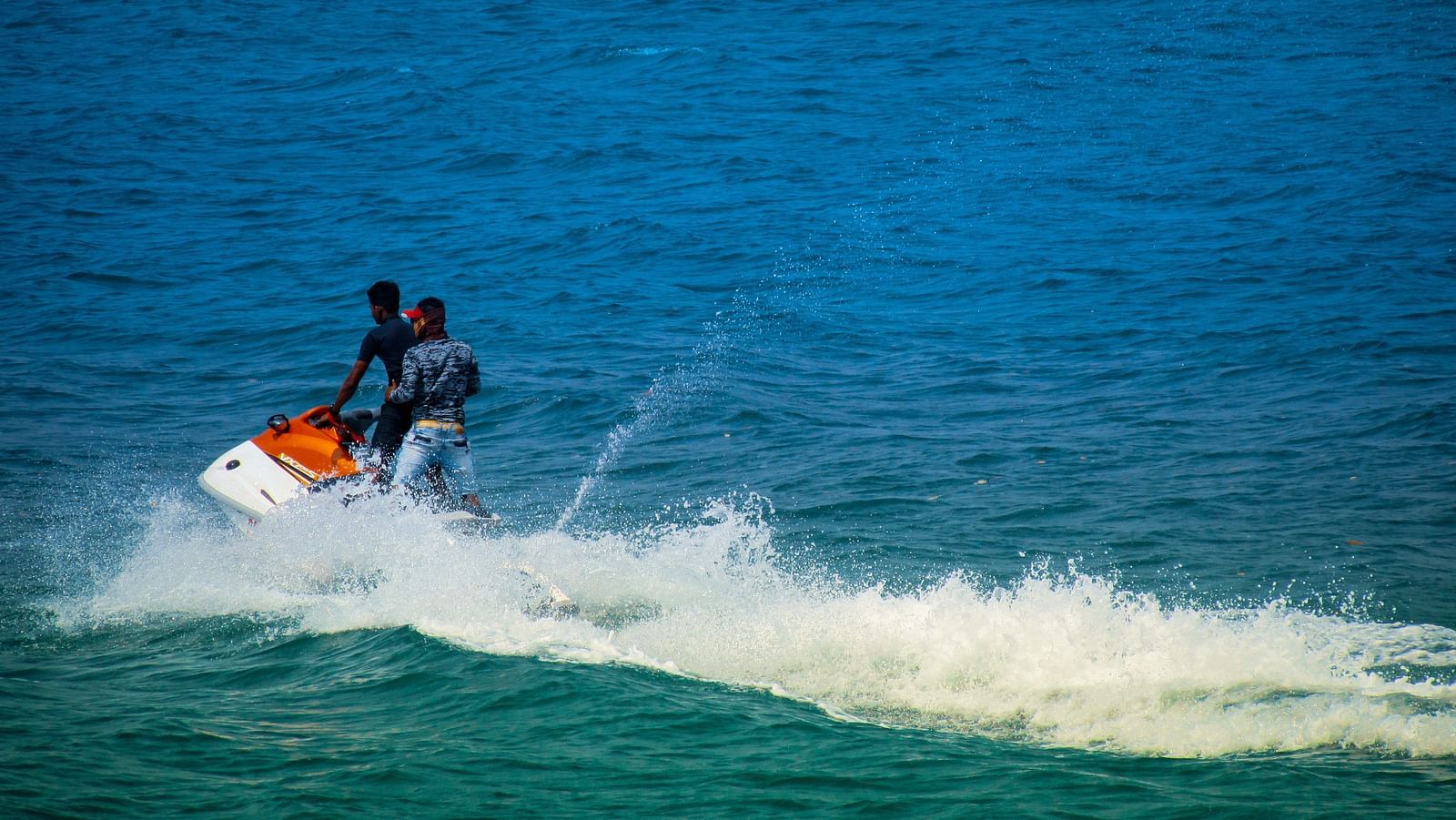 two people standing on a Jetski performing water sports in South Goa