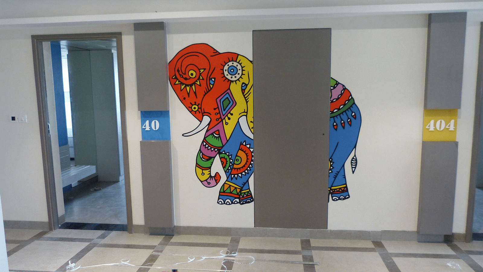 An elephant painted in various colours is on the wall
