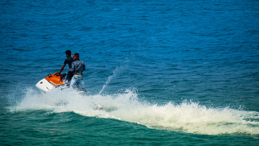 two people standing on a Jetski performing water sports in South Goa