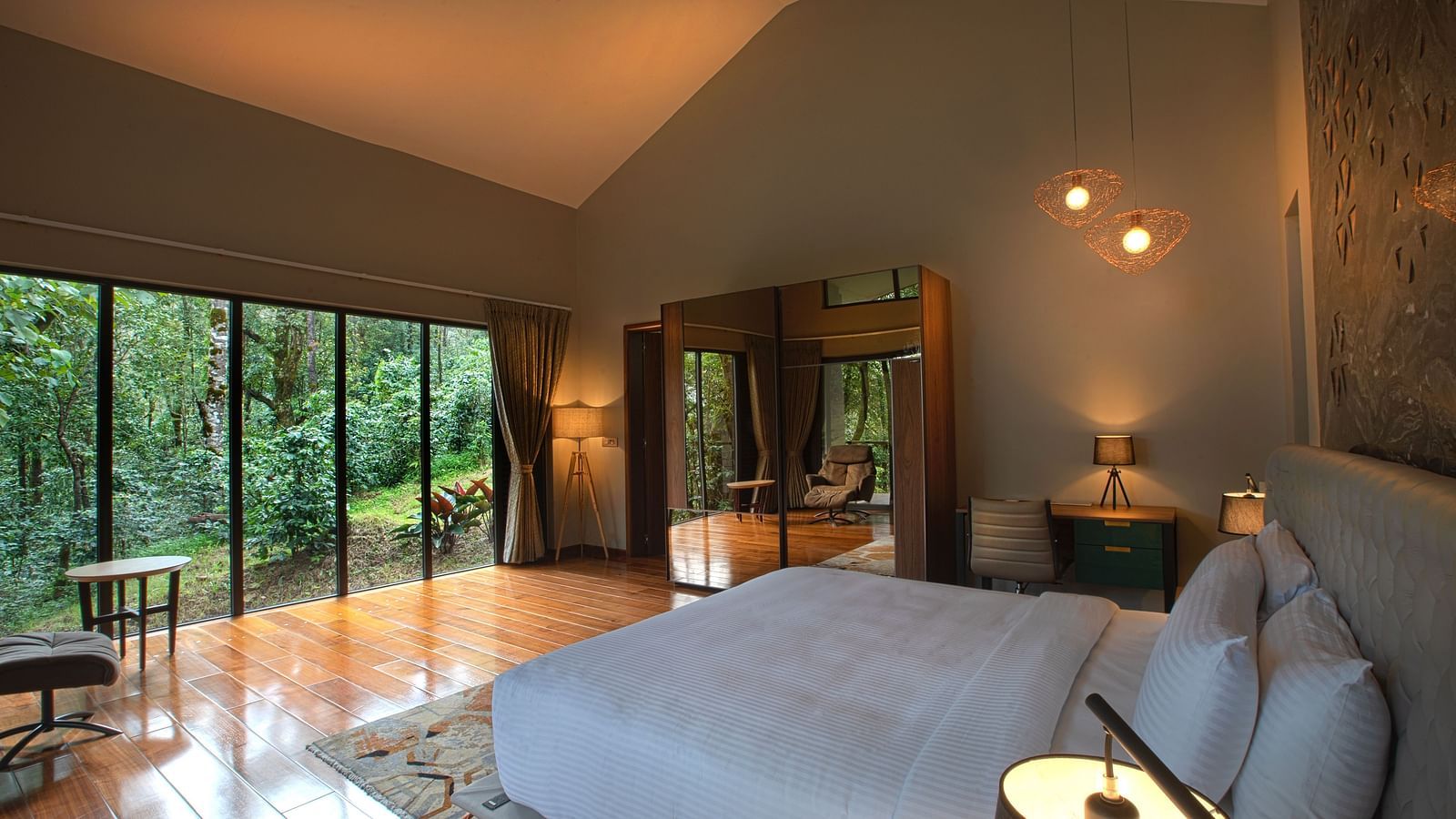 Side view of a room with a bed and large glass wall in front at Stanley Revelation.