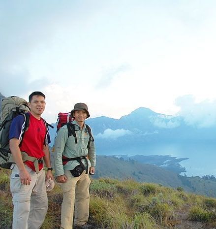 Travelers hiking with panoramic views of a mountain lake.