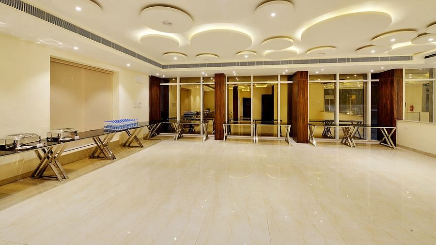 Large hall with buffet tables along the walls, featuring wooden columns and a glossy floor.